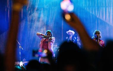 Two male artists singing into microphones.