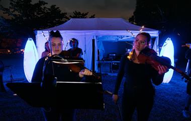 Two female performers playing music instruments.