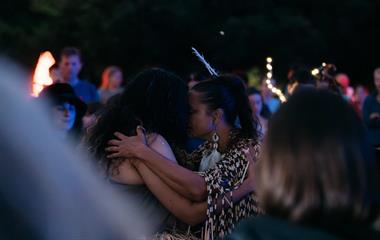 Two females embracing each other with their foreheads touching.