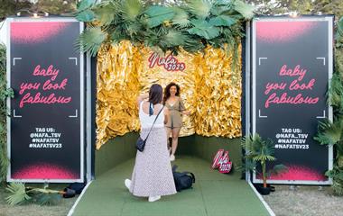 Two women taking a photo in a photobooth.